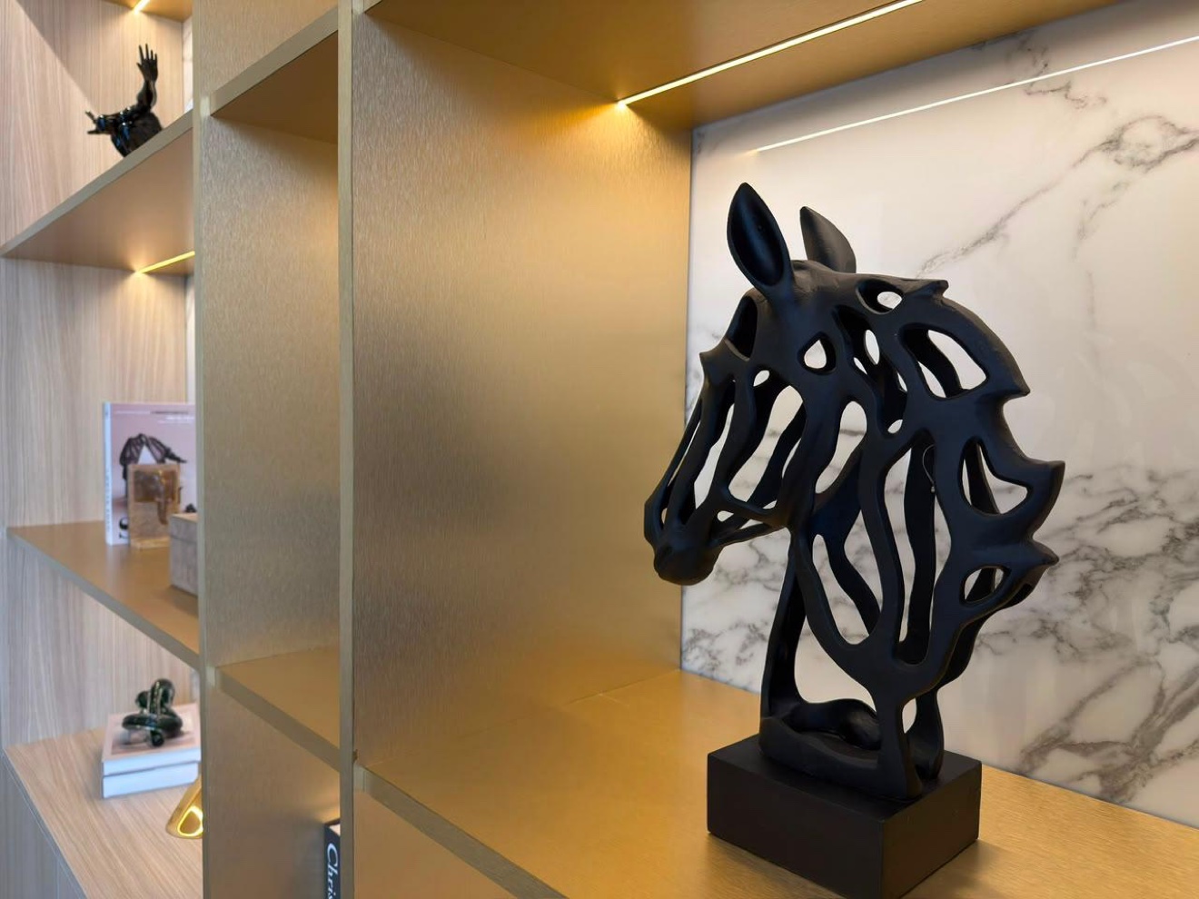 Sculptural horse artwork detail in stone and brass