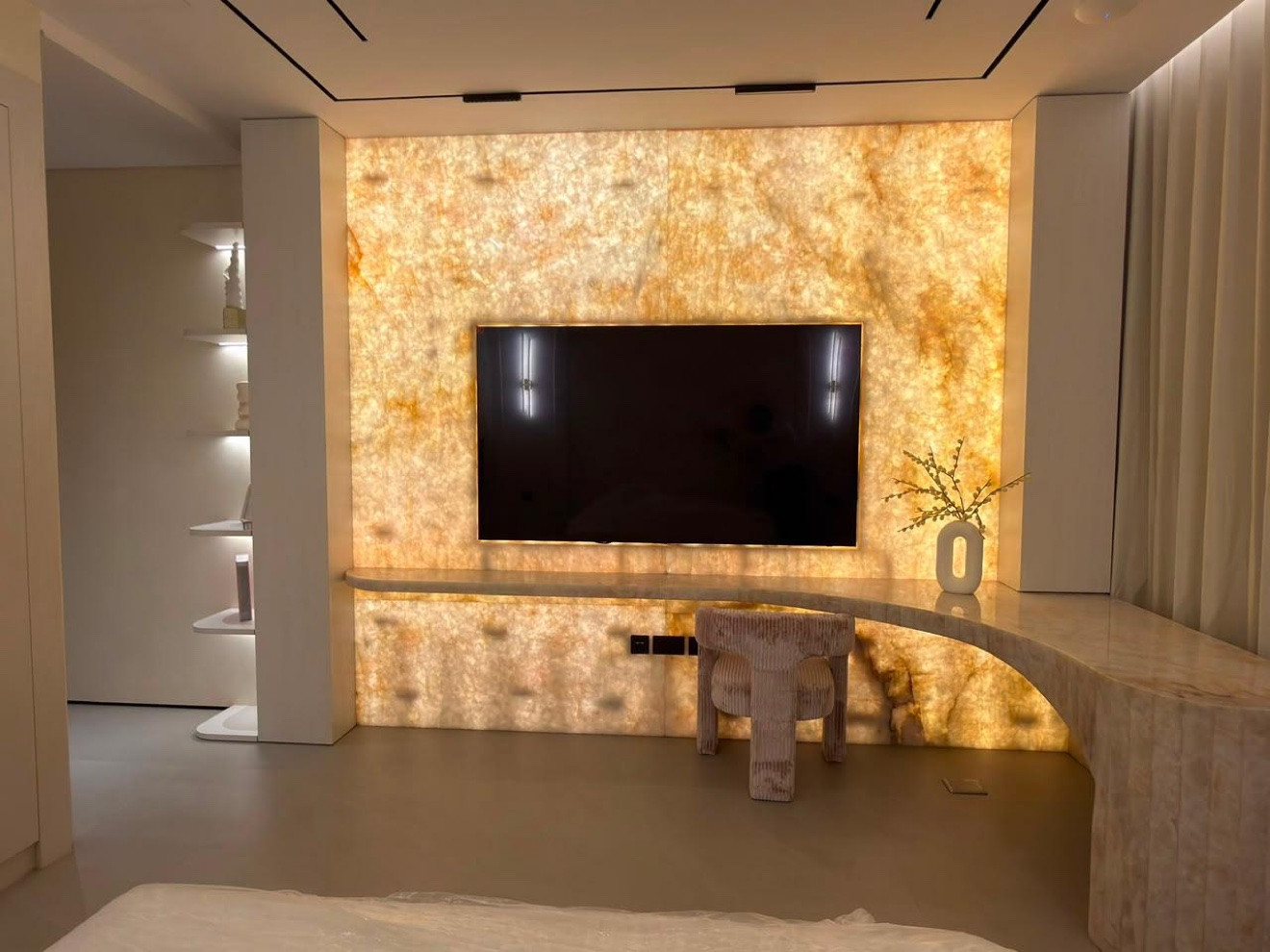 Entertainment wall in backlit natural stone with integrated display niches