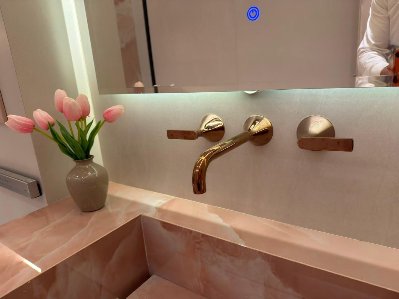 Marble basin detail with brushed brass faucet
