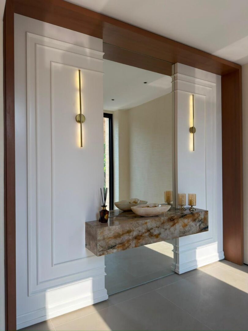 Powder room with curved mirror, marble console and stone-clad walls