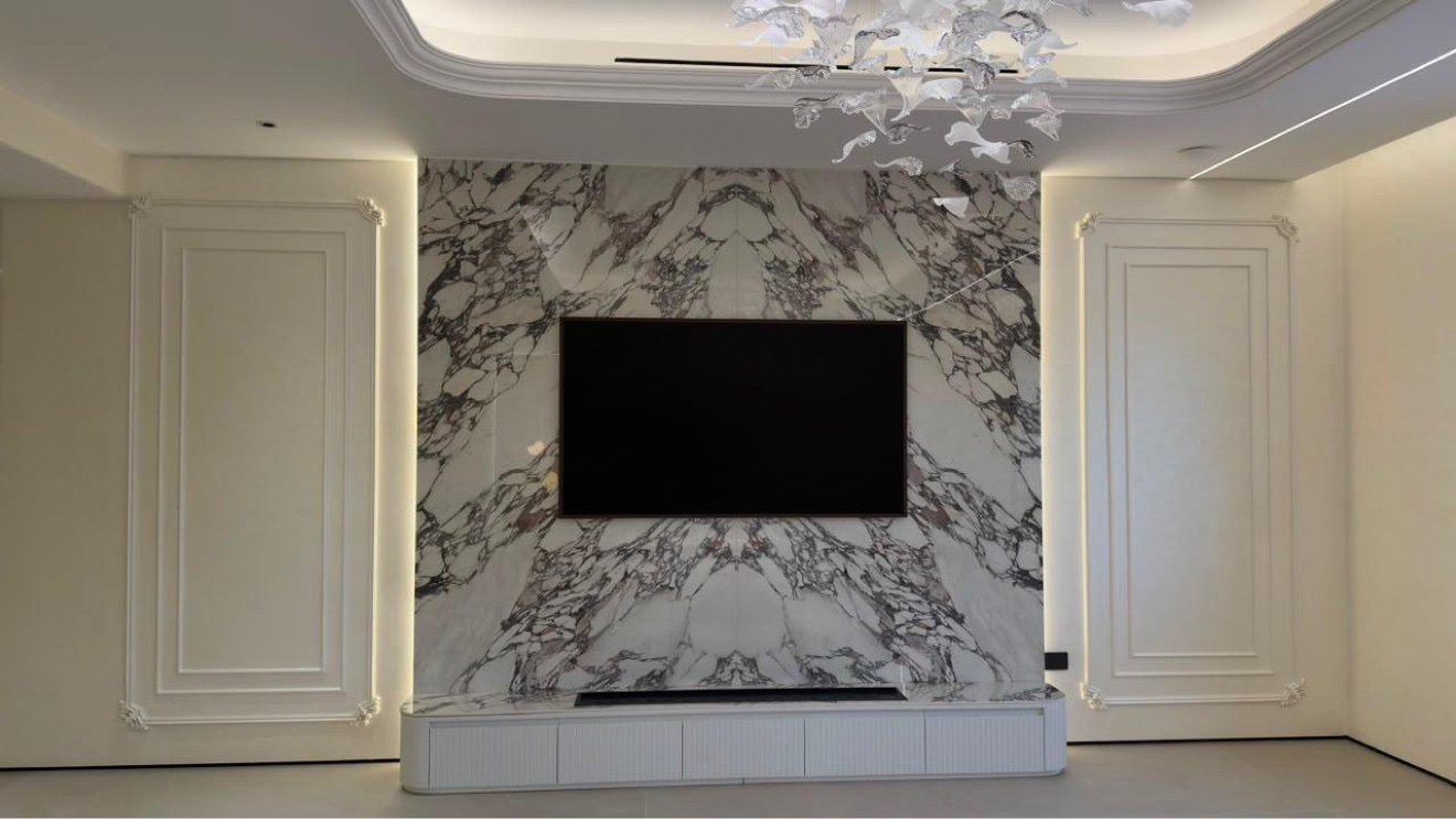 Living room with book-matched marble feature wall and brass wall lights in a Jumeirah Golf Estates villa